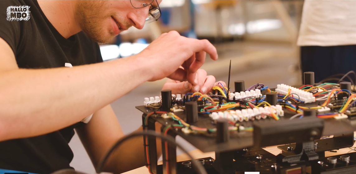 Student voert nauwkeurige elektrotechnische werkzaamheden uit aan een bedradingspaneel