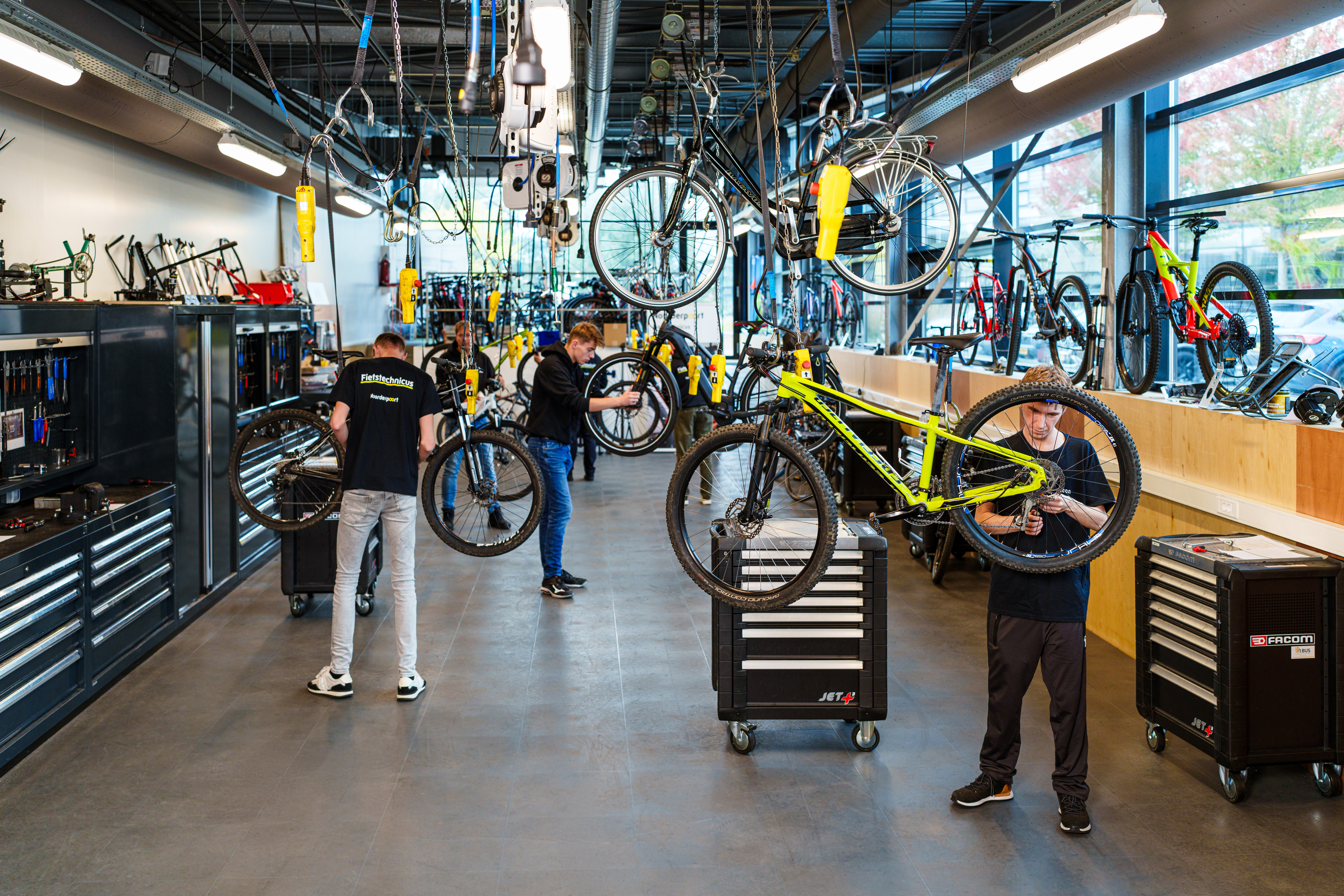 Studenten werken samen aan fietsenreparatie in een leerwerkplaats van Noorderpoort.
