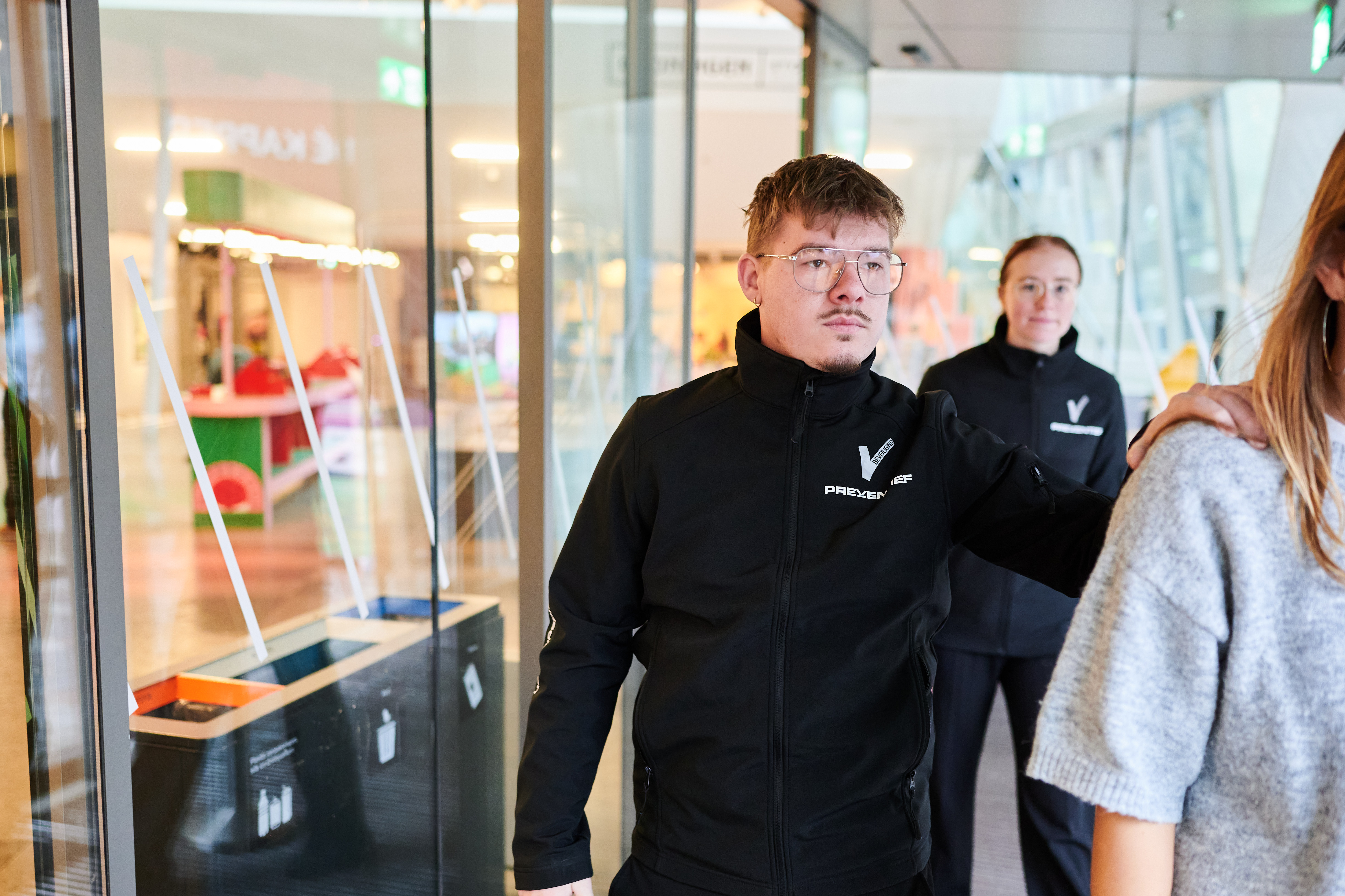 Beveiligingsmedewerker begeleidt een bezoeker in het onderwijsgebouw van Noorderpoort.