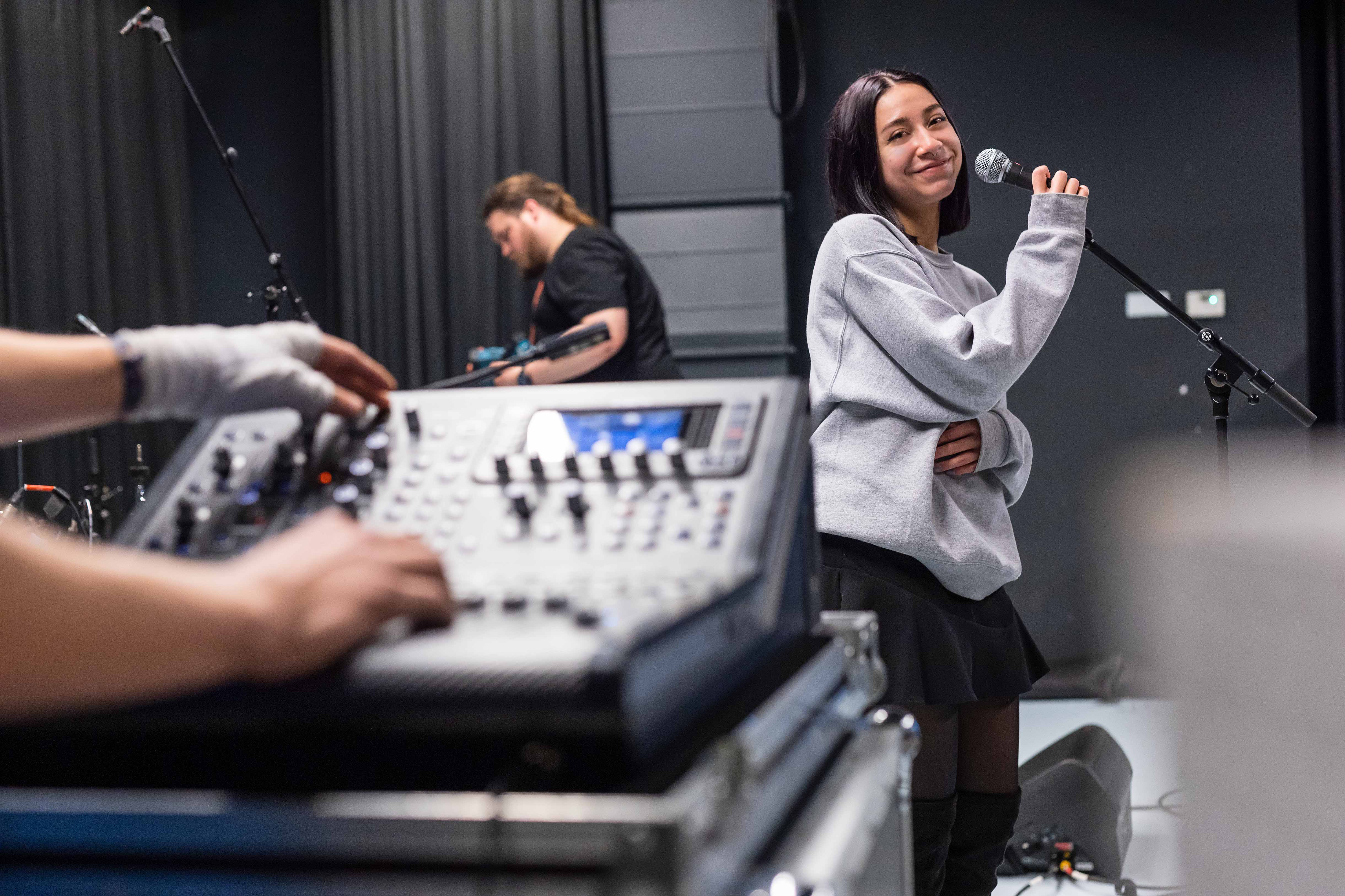 Beginnend artiest oefent zang in studio met ondersteuning van geluidstechnicus