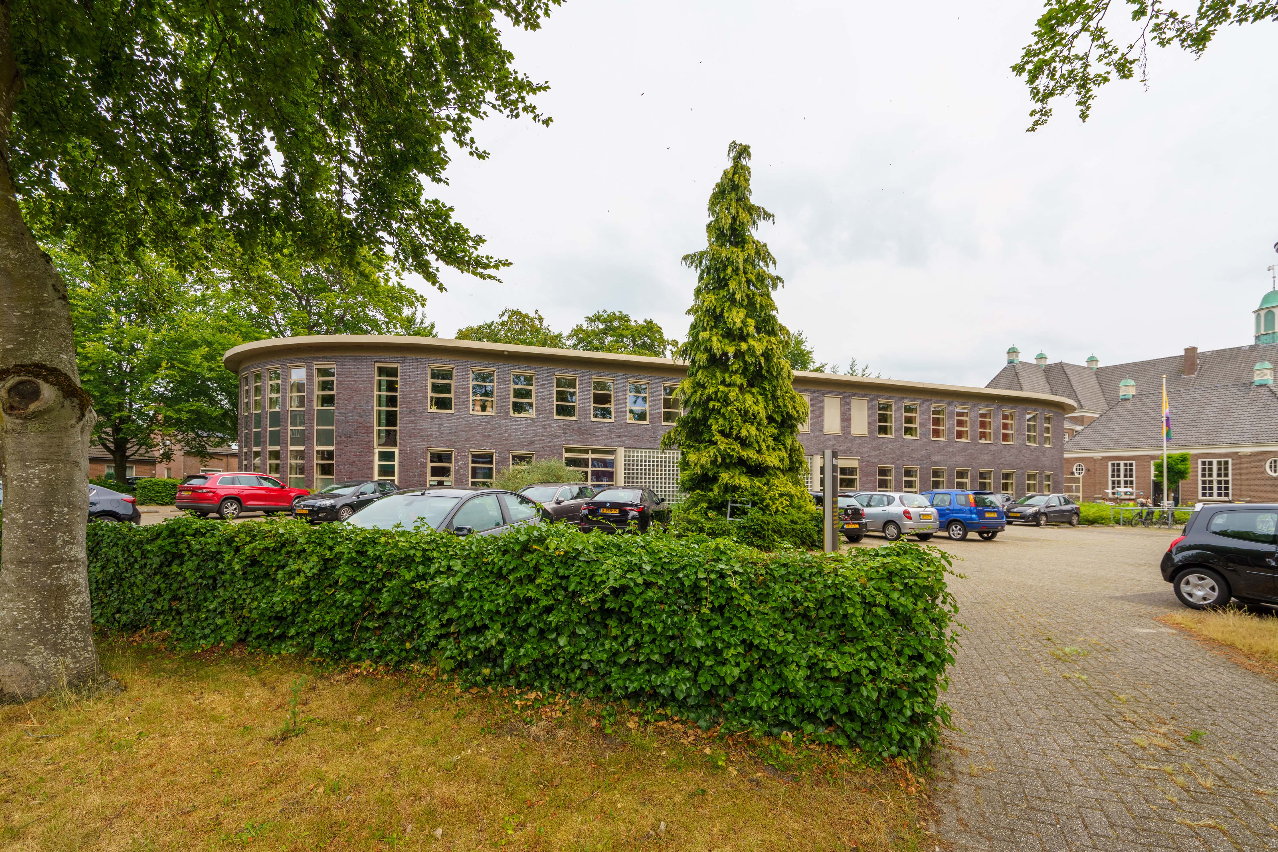 Onderwijsgebouw Noorderpoort aan Hertenkampstraat 6 in Veendam met omringende parkeerplaatsen.