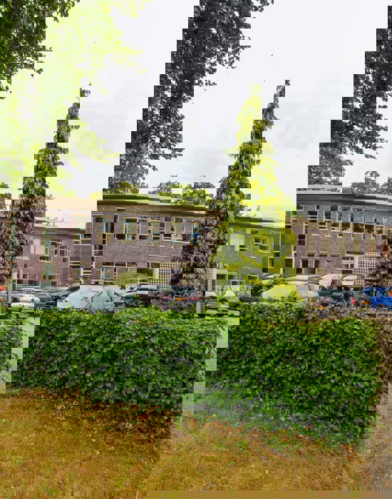 Onderwijsgebouw Noorderpoort aan Hertenkampstraat 6 in Veendam met omringende parkeerplaatsen.