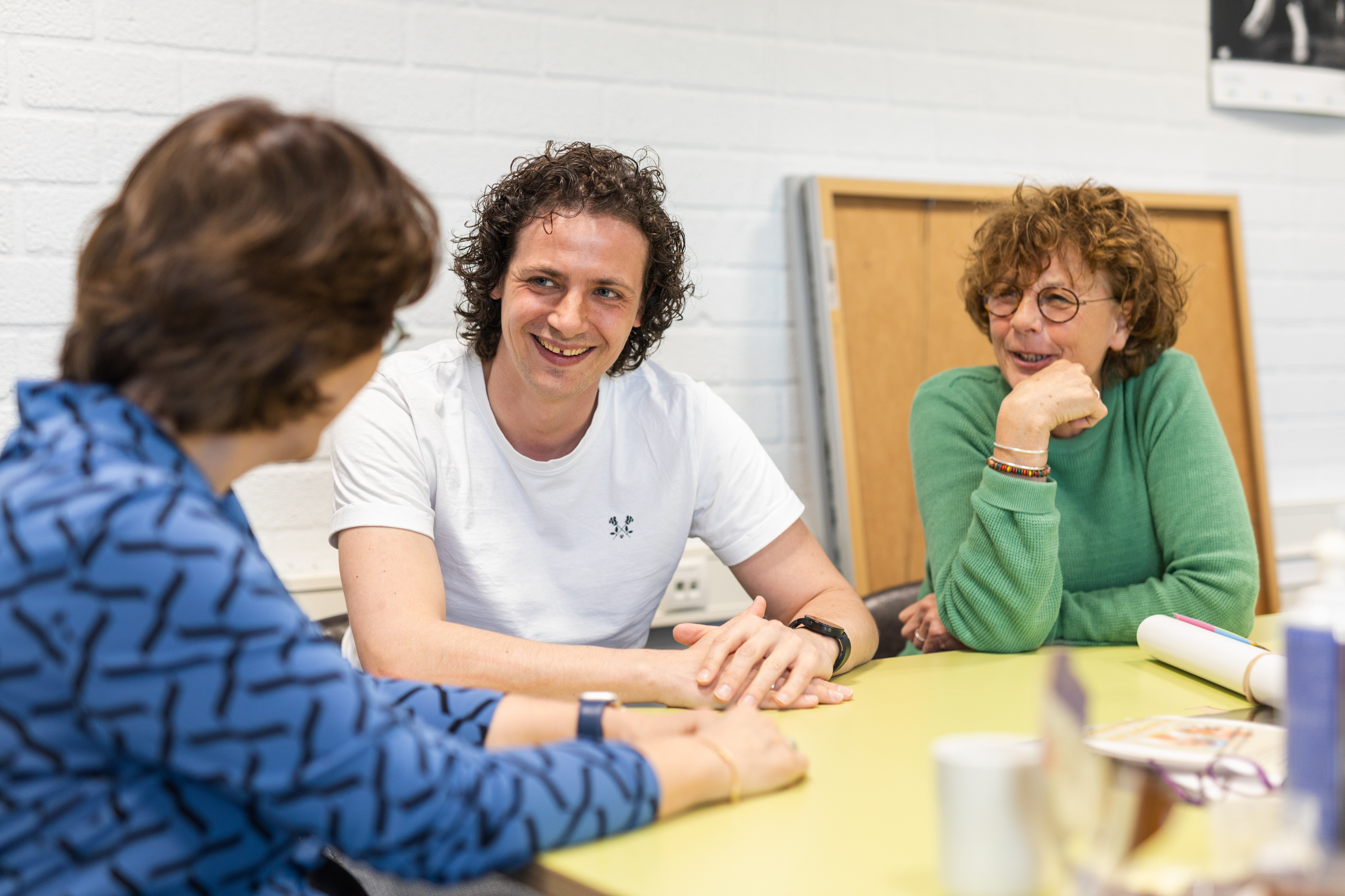 Drie personen in gesprek tijdens een overlegmoment bij een mbo-onderwijsorganisatie.