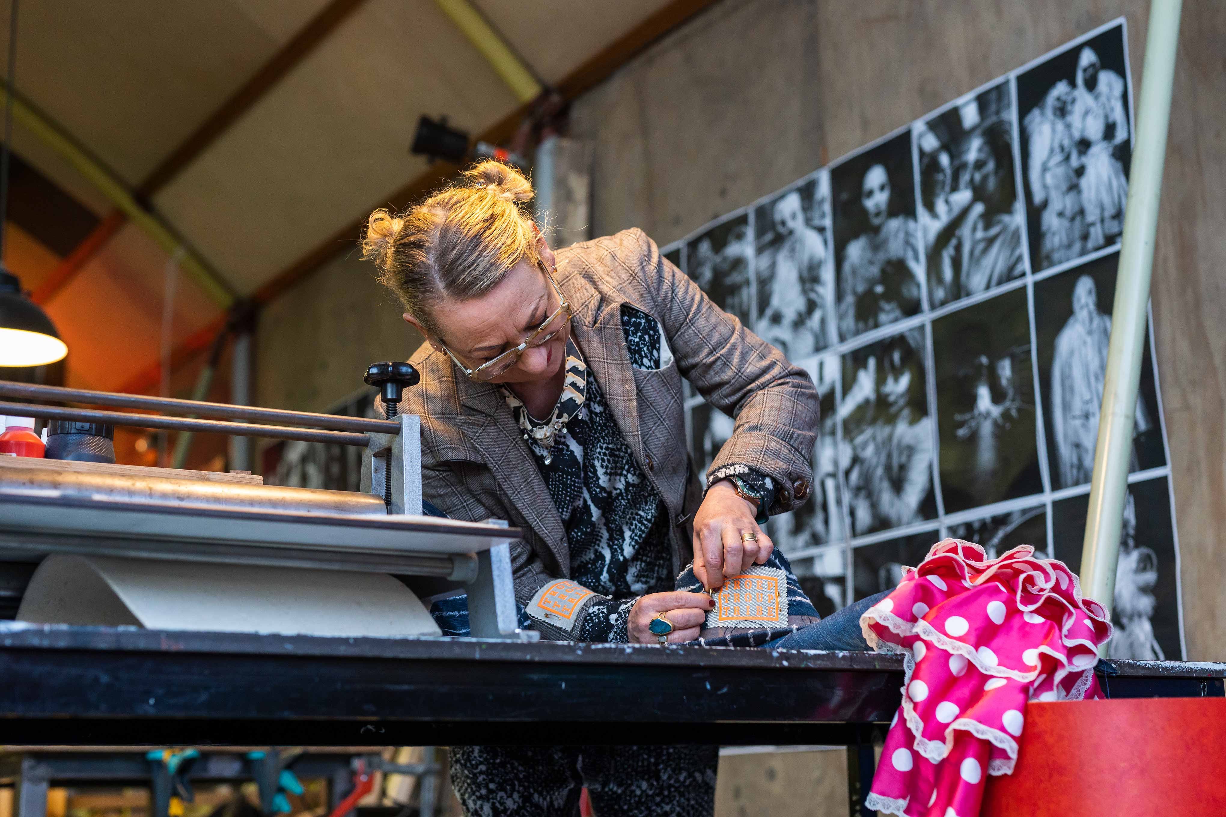 Docent werkt geconcentreerd met artistieke materialen aan een duurzaam project in een creatieve werkruimte