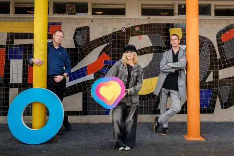 Drie personen bij kleurrijke muurschildering, passend bij introductiekamp Groen Goud voor nieuwe studenten