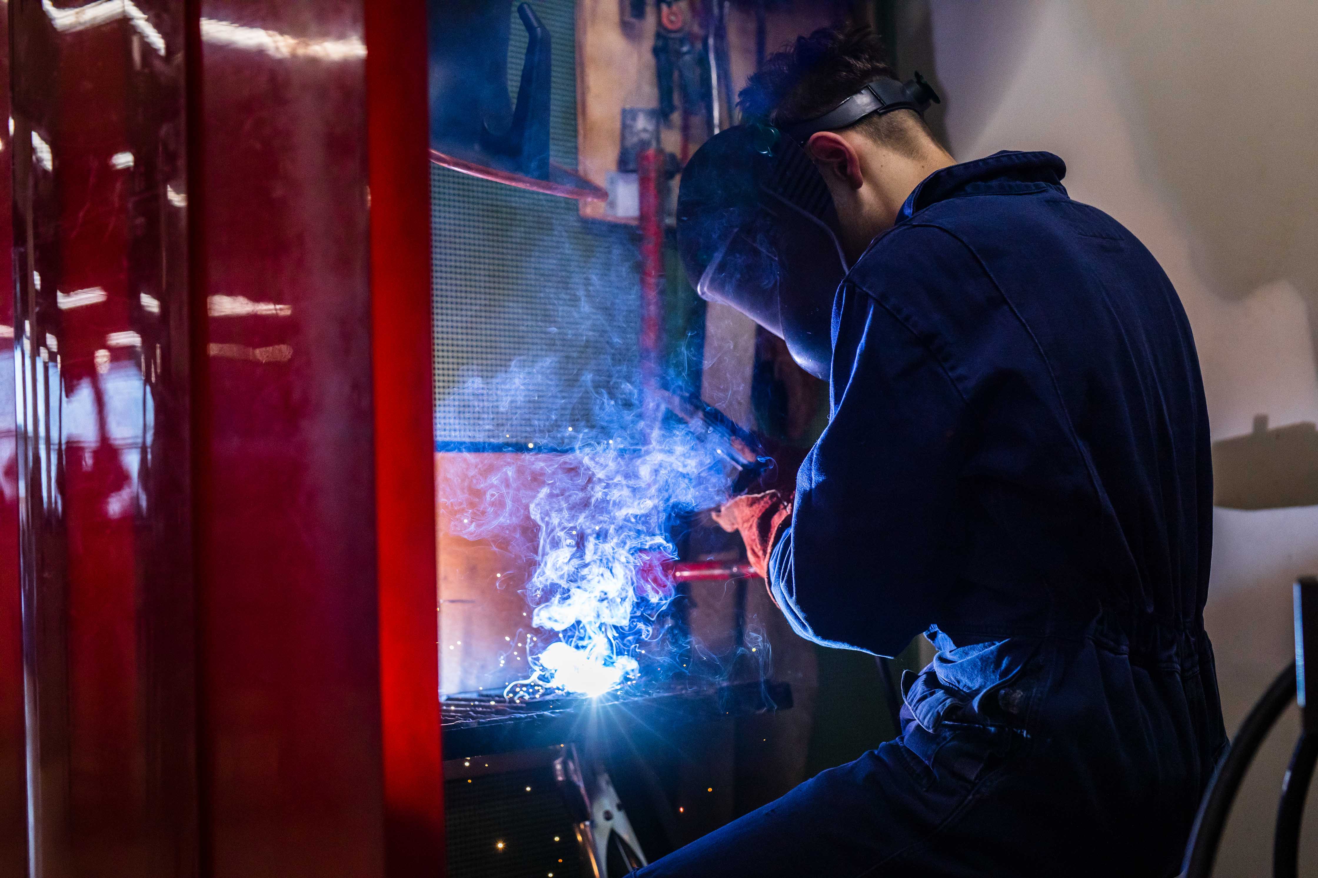 Technicus voert lastoepassing uit bij een machine, gericht op techniek en procestechniek