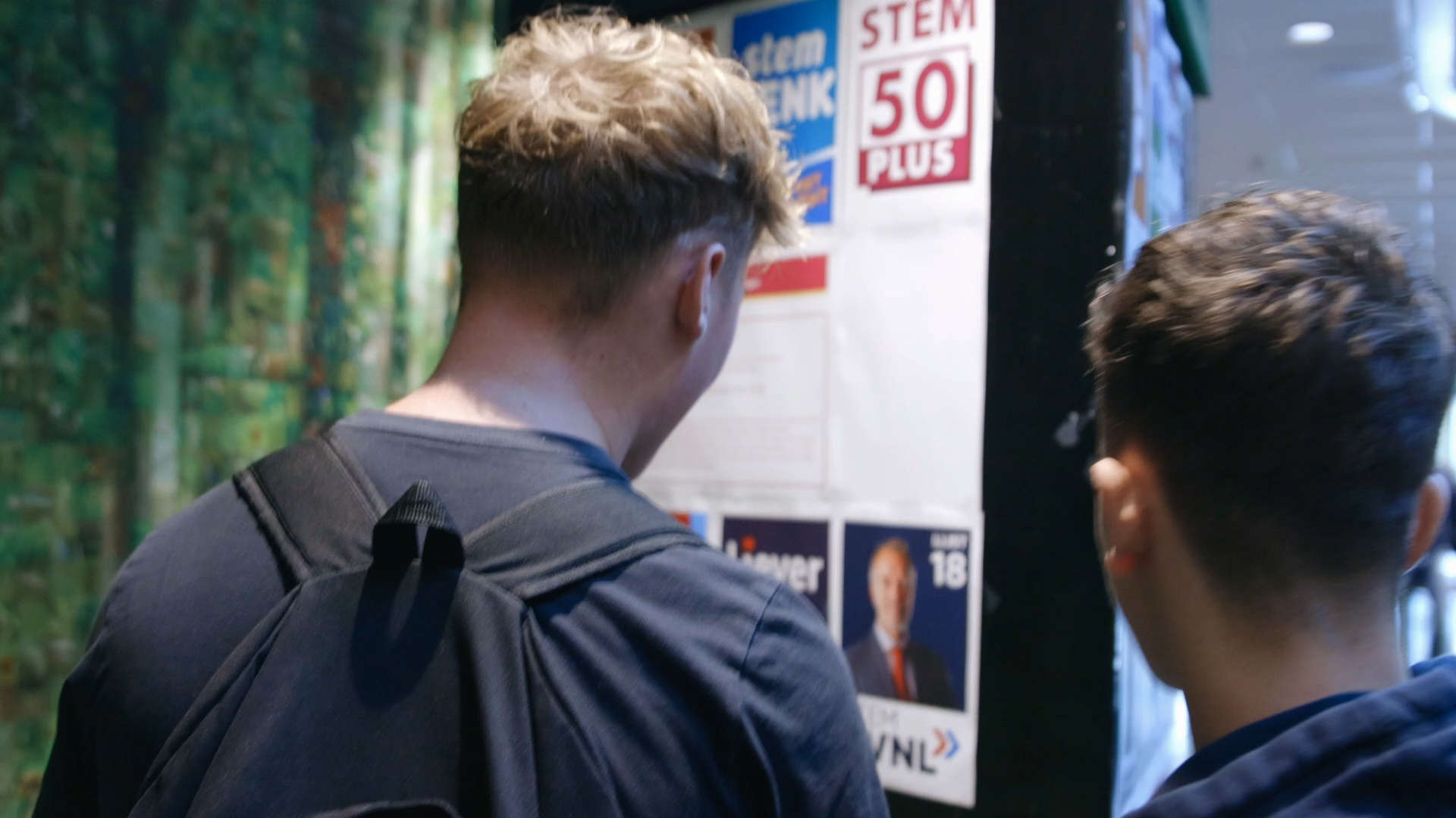 Twee studenten bekijken informatiemateriaal over de EU-verkiezingen tijdens een evenement van Noorderpoort