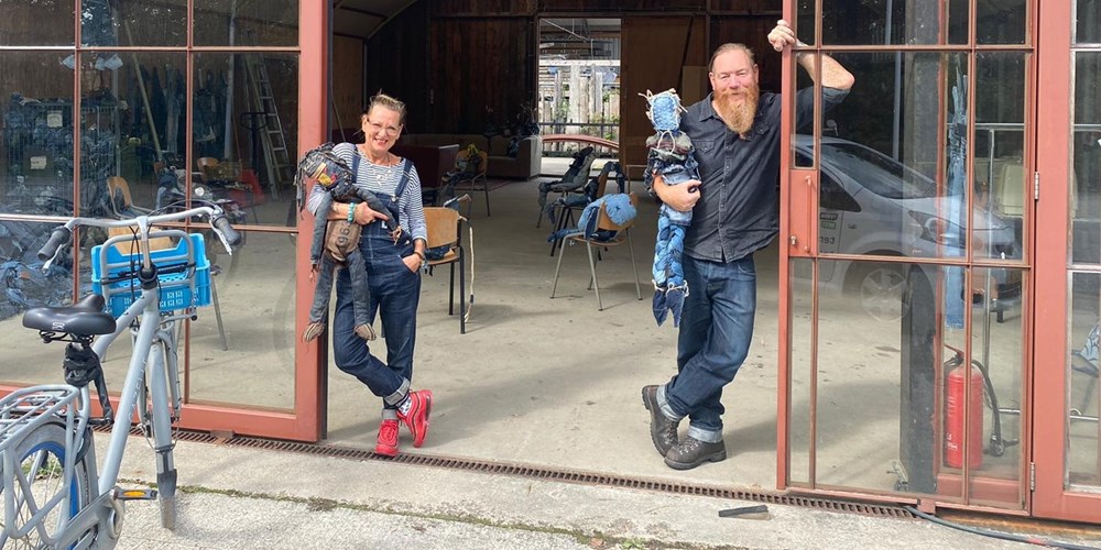Twee docenten van Noorderpoort poseren met poppen in een open werkruimte, zichtbaar betrokken bij onderwijsinnovatie.