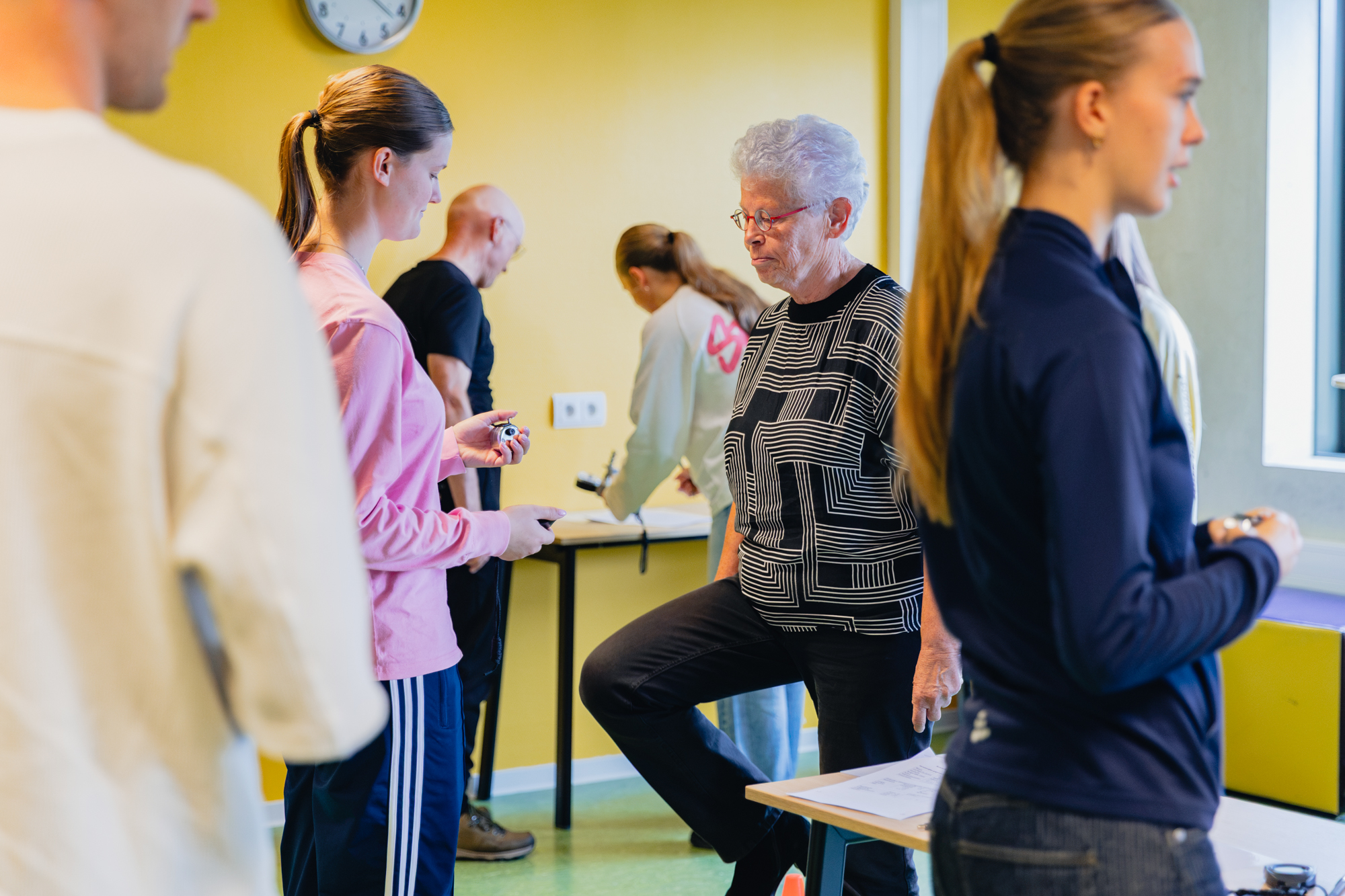 Studenten begeleiden 55-plussers bij fysieke fitheidstests in een sportruimte in Winschoten.