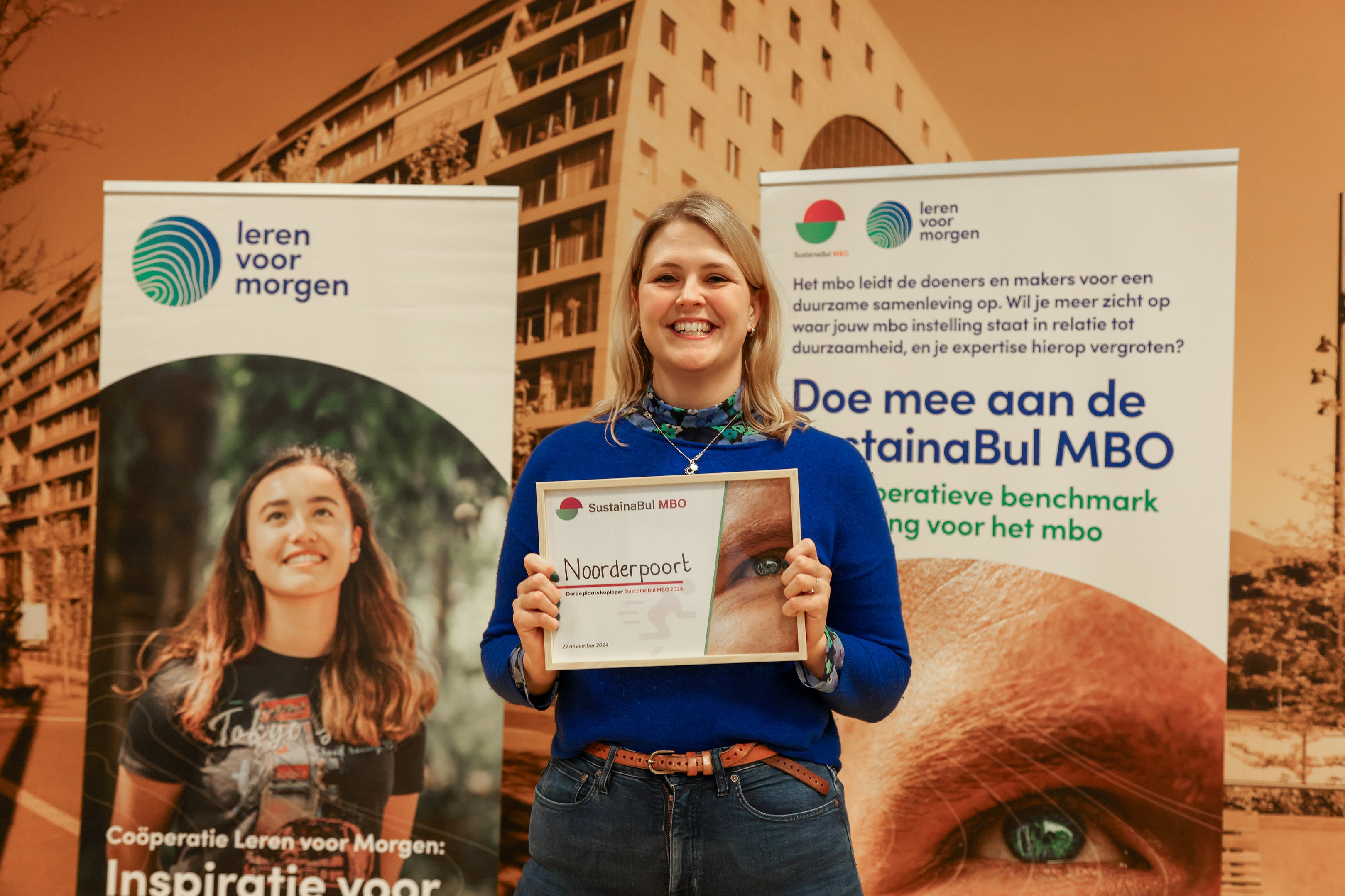 Medewerker van Noorderpoort toont een certificaat voor de derde plaats in de Sustainabul duurzaamheid benchmark