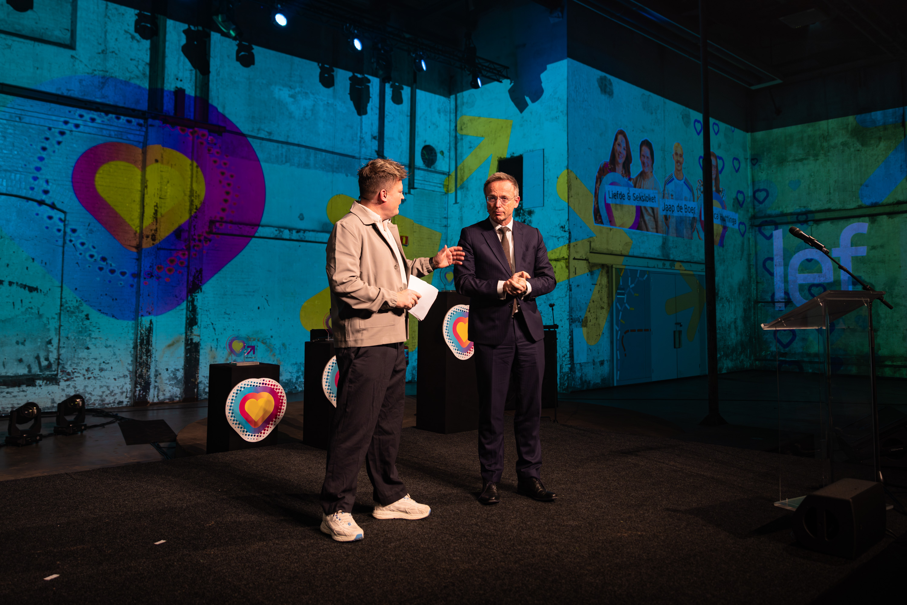 Twee personen in gesprek op een podium tijdens de Noorderpoort Jaarprijs 2025 jubileumeditie.