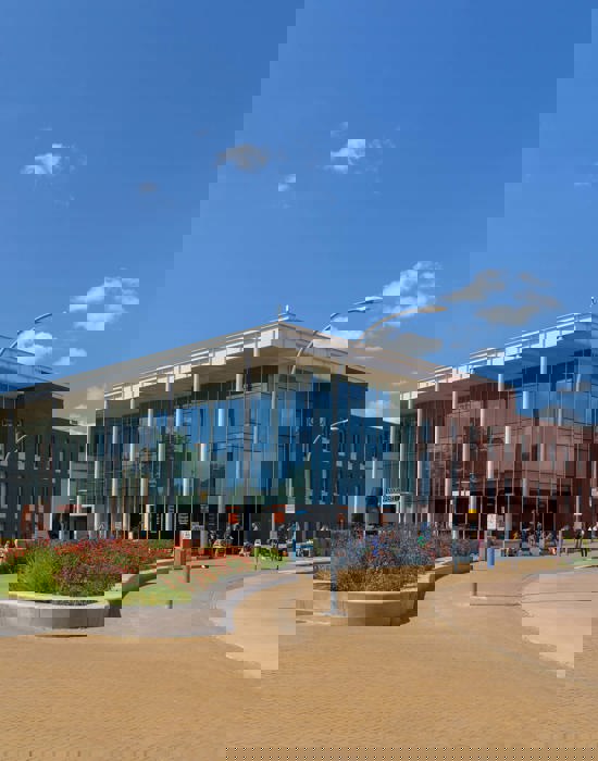 Noorderpoort onderwijsgebouw aan Zernikeplein 11 in Groningen met studenten bij de ingang op een zonnige dag