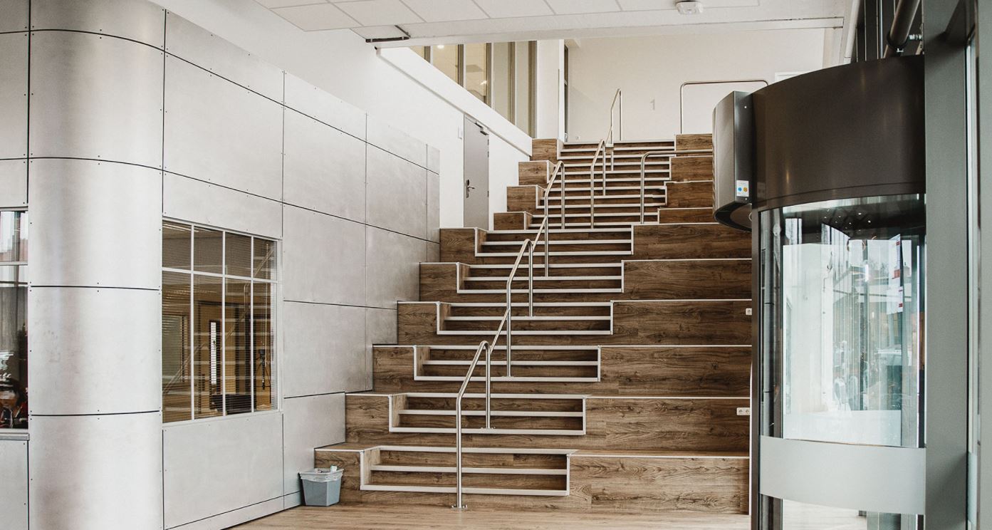 Ruimtelijke trap met houten treden en metalen leuningen in het Noorderpoort-pand aan de Muntinglaan in Groningen