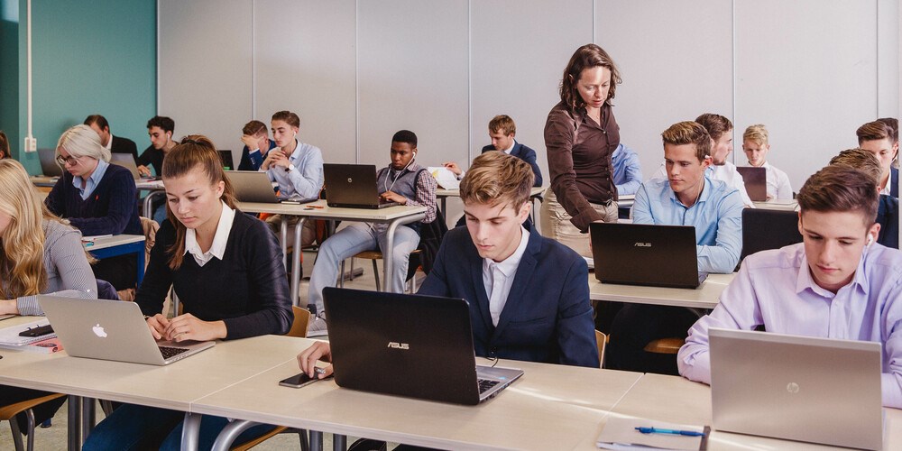 Studenten werken geconcentreerd aan laptops tijdens een les over digitaal burgerschap binnen Noorderpoort.