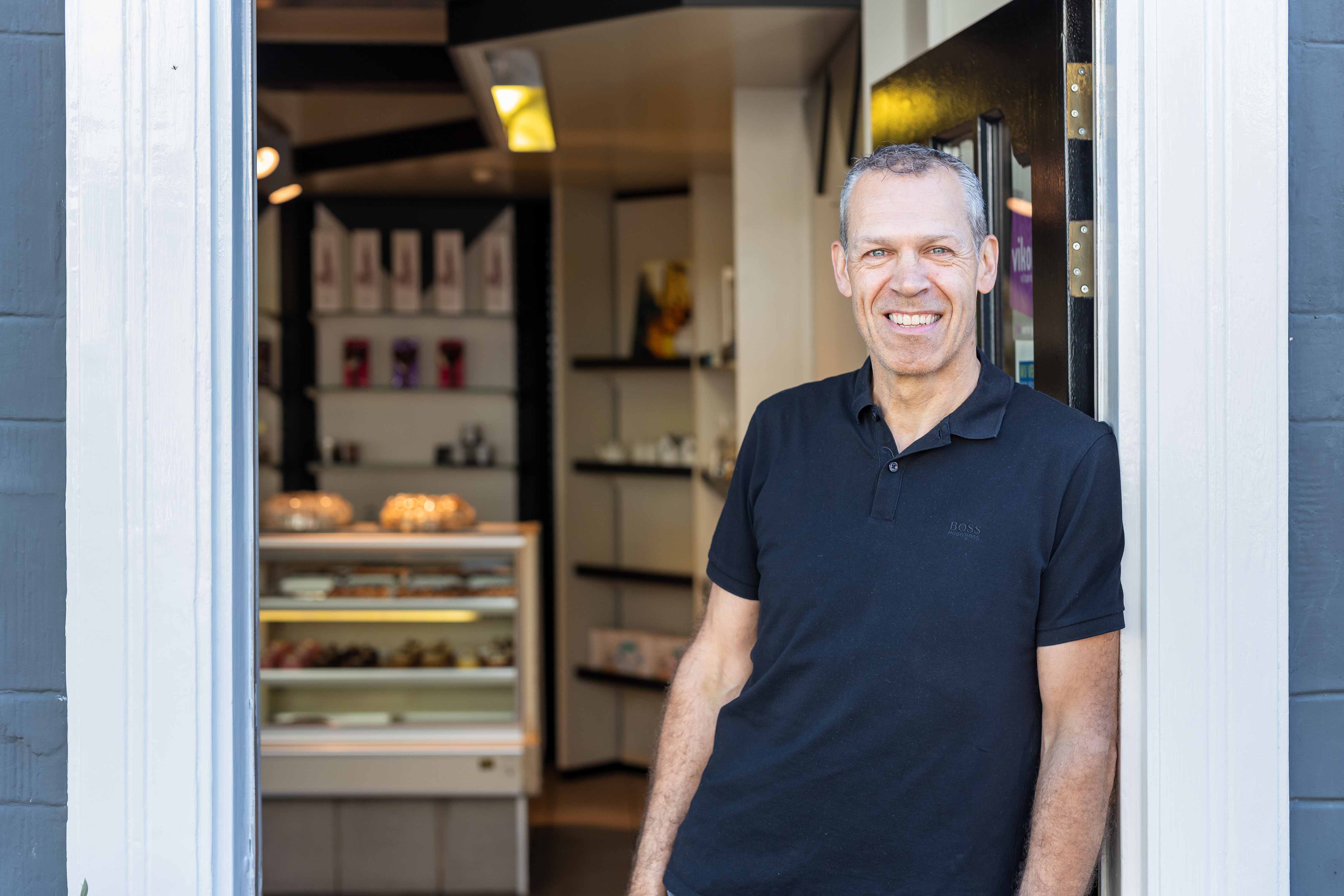 Docent met ruime ervaring in het bakkersvak staat in de ingang van een leerbakkerij.