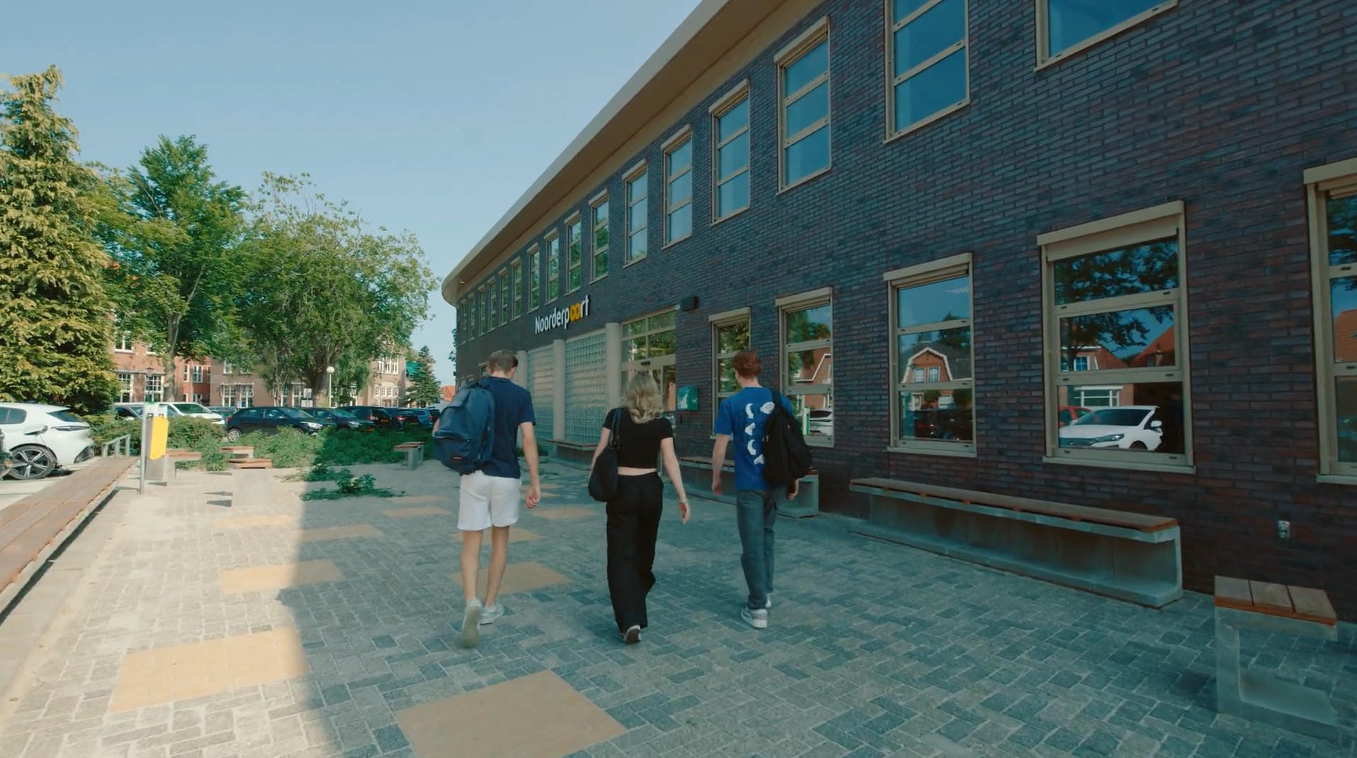 Drie studenten lopen naar de ingang van het Noorderpoort gebouw aan de Hertenkampstraat in Veendam.
