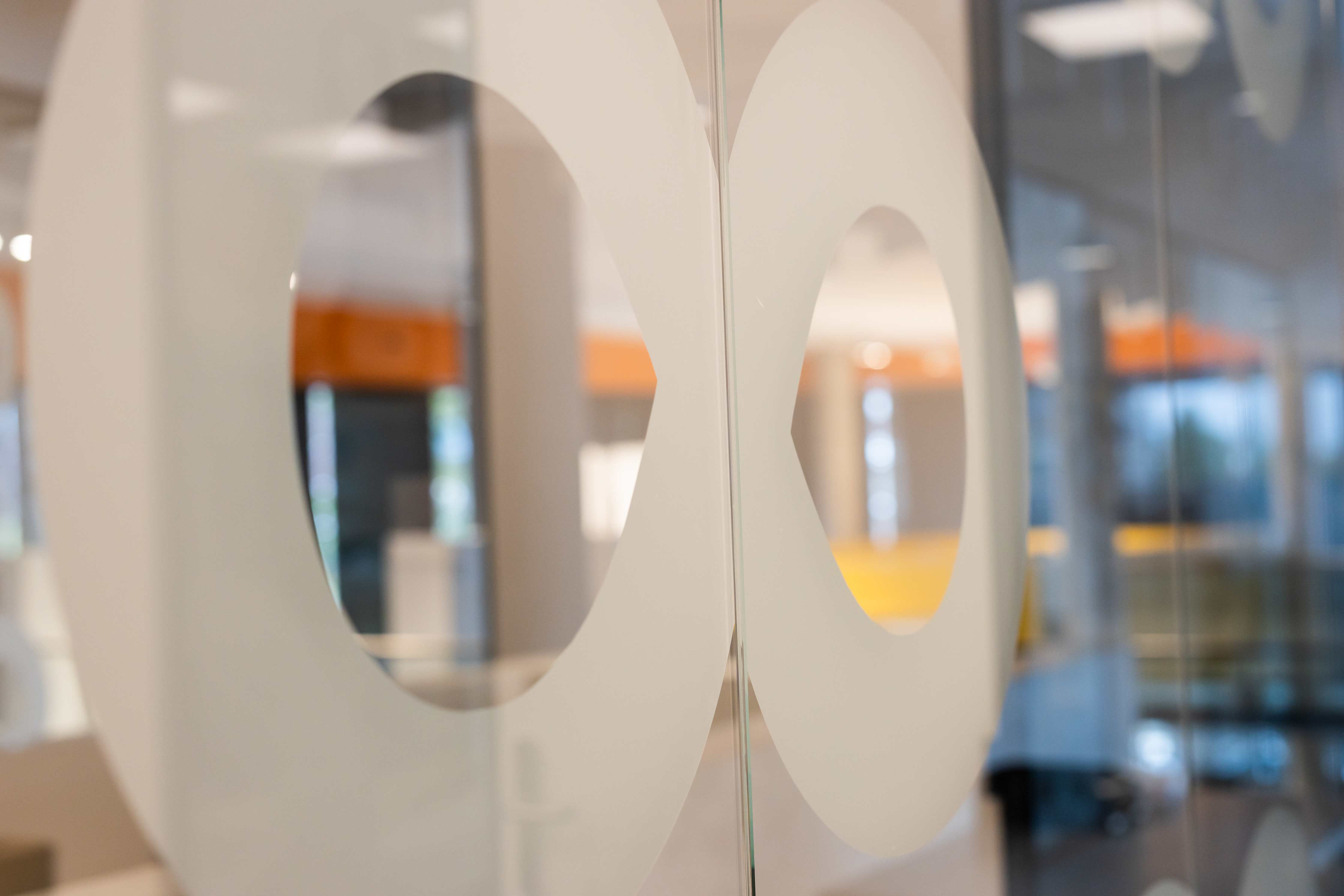 Interieur van een moderne onderwijsinstelling met focus op het logo van Noorderpoort op een glazen wand
