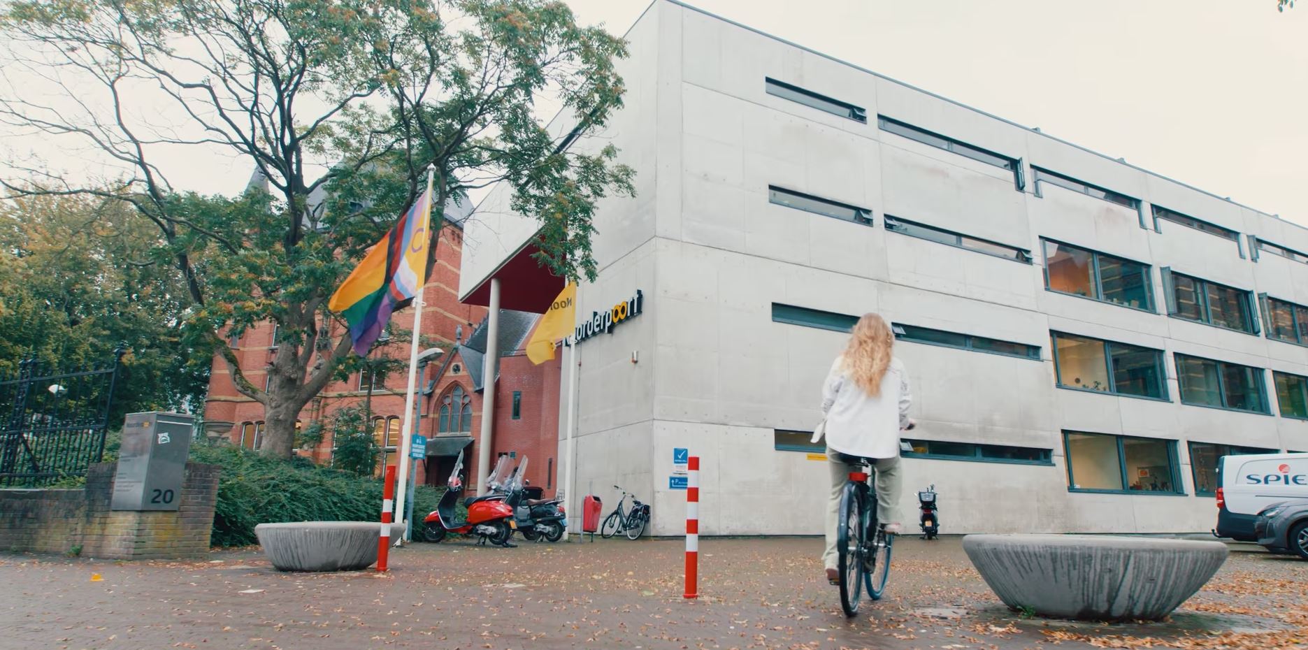 Student fietst richting het onderwijsgebouw van Noorderpoort aan Verlengde Visserstraat 20 in Groningen