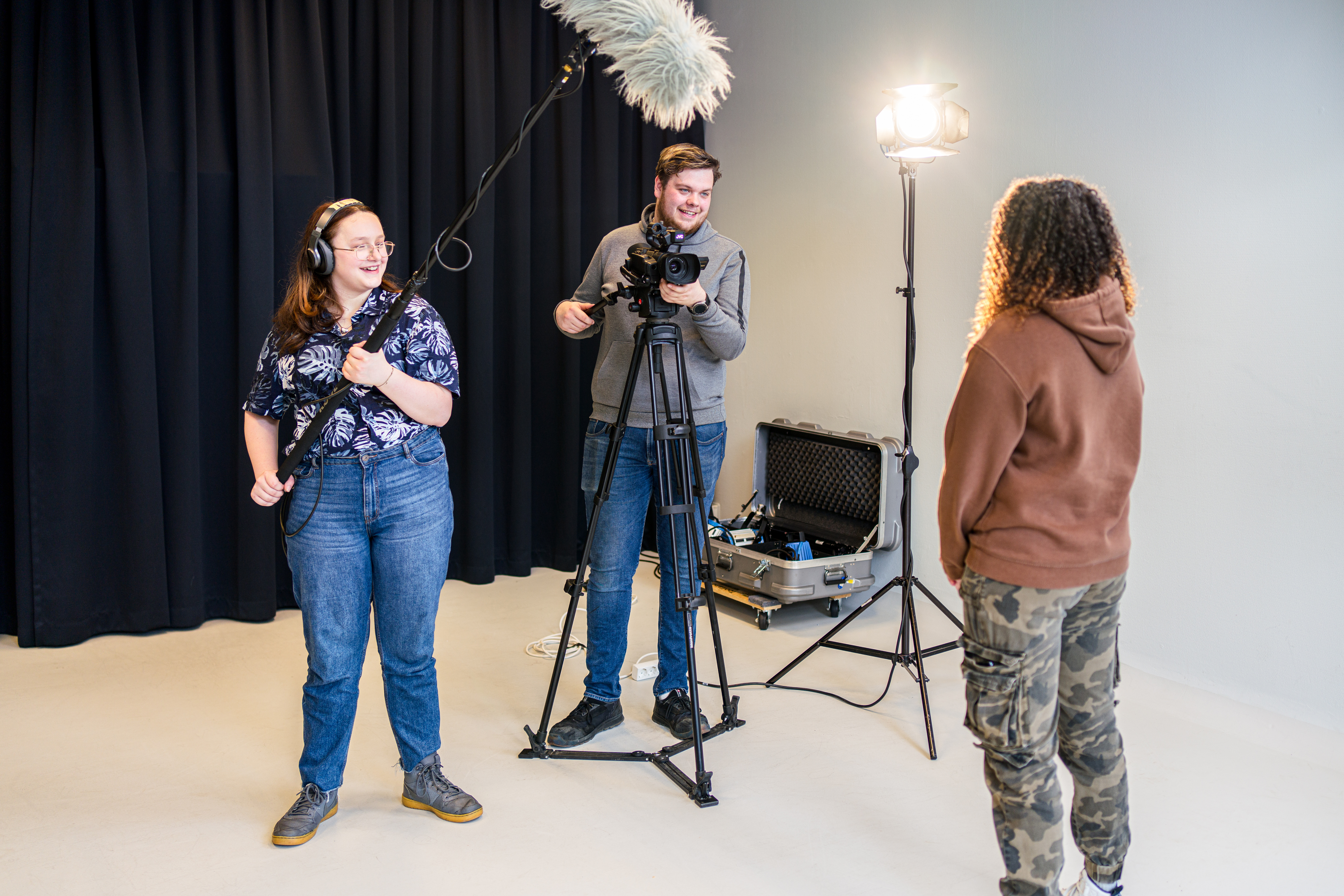 Medewerkers filmen een gesprek met een student tijdens een media-opname in een studio