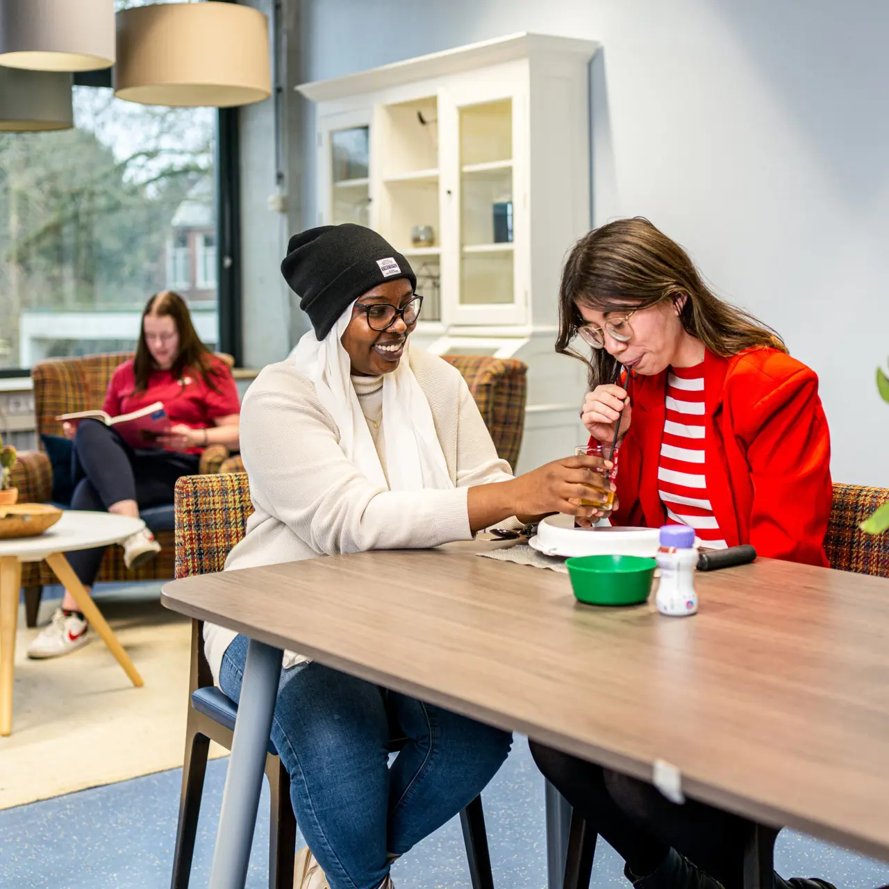 Twee studenten voeren samen een verzorgingsoefening uit tijdens een les in een studieruimte van Noorderpoort.