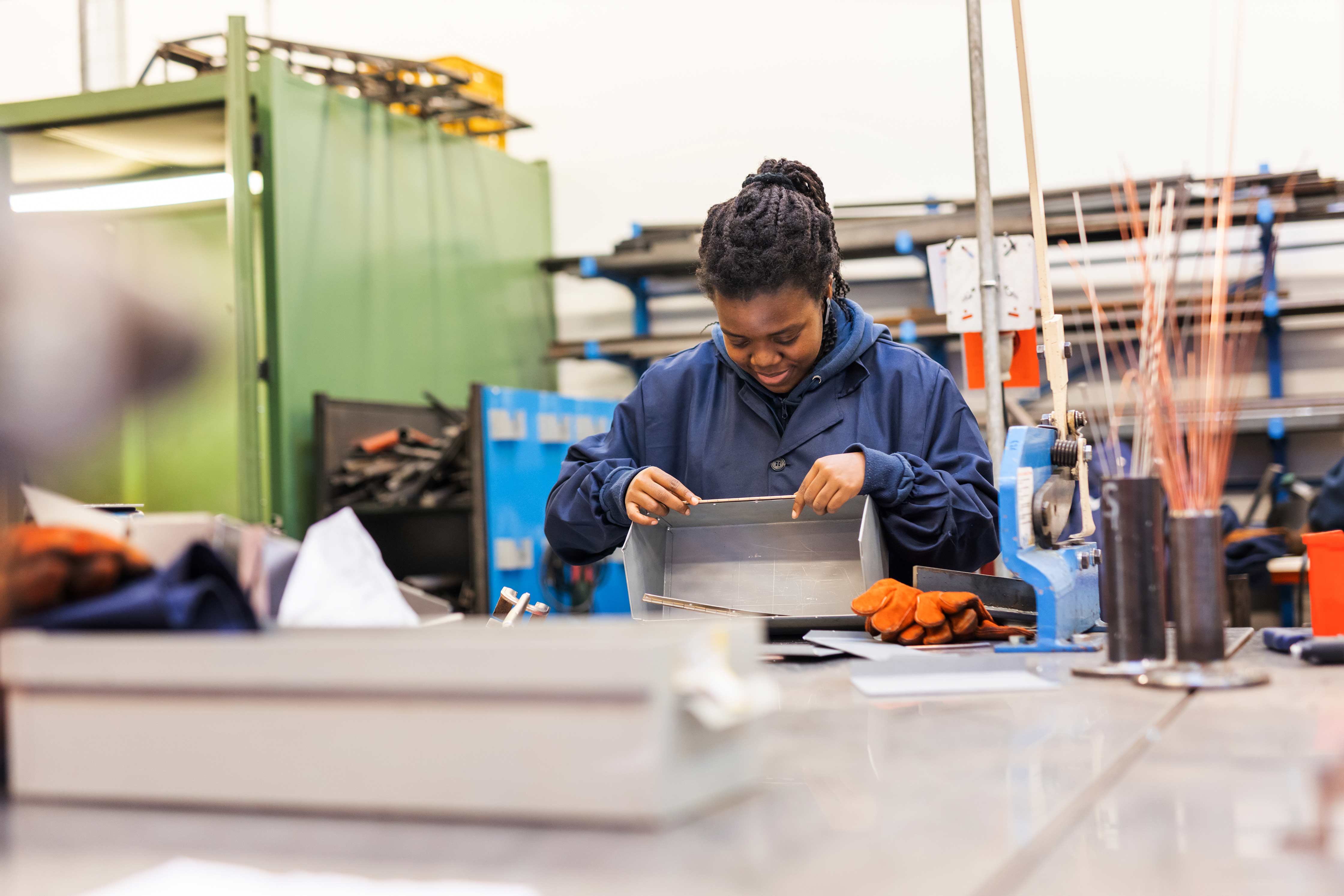 Student werkt geconcentreerd aan een metalen constructie in een praktijkruimte van een techniekopleiding.