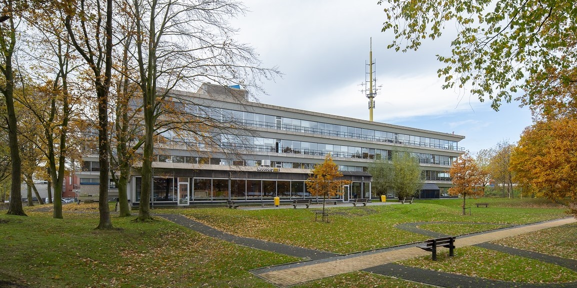 Exterieur van het onderwijsgebouw aan Winschoterdiep 50 met groene buitenruimte en wandelpaden