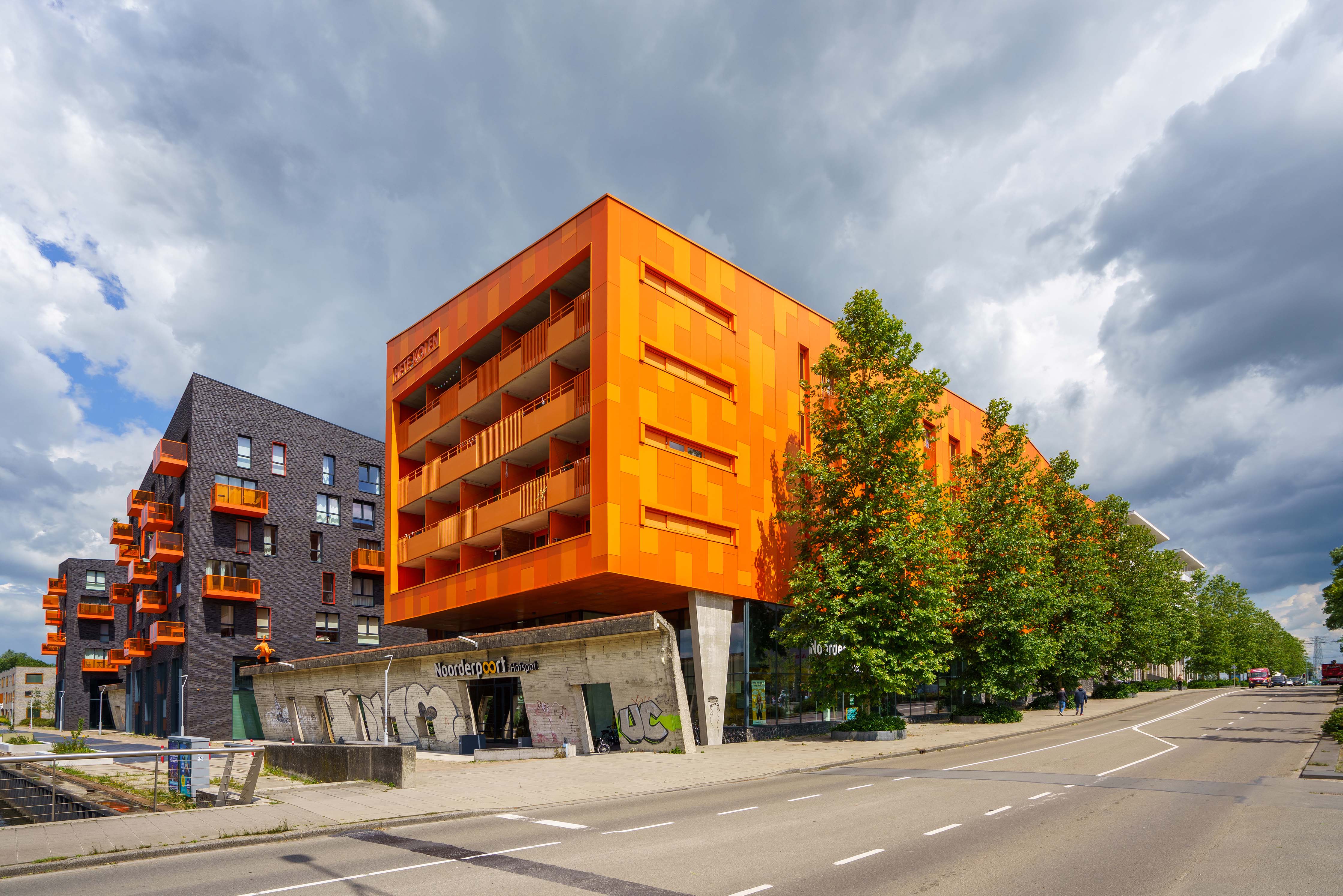 Moderne onderwijsgebouwen van Noorderpoort aan Boumaboulevard 400 in Groningen met kleurcontrast en boomrij.