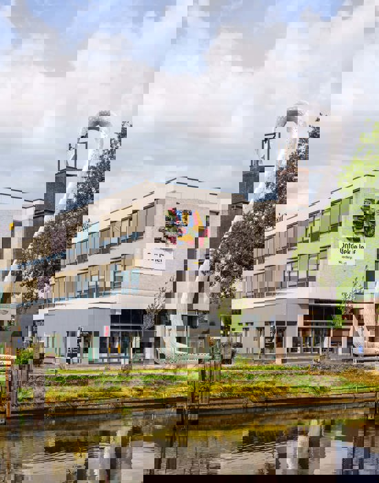 Onderwijslocatie Noorderpoort Muntinglaan 3 in Groningen met kenmerkende kunstinstallatie bij water